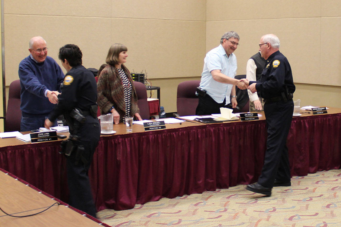 Angelo Bruscas/North Coast News                                Retiring Ocean Shores Police Chief Mike Styner and newly named new Chief Neccie Logan shake hands with City Council members on Monday.