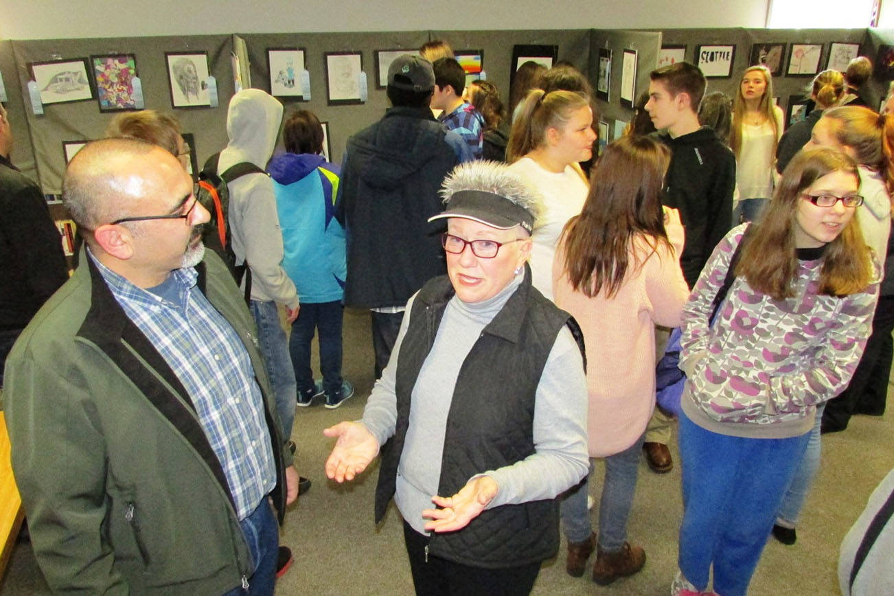 Scott D. Johnston photo: NBHS art teacher Richard Villar and AAOS event organizer Kathy Harris enjoying the results of their efforts, and those of 47 young artists, at the 1st Annual AAOS Youth Fine Art Open Show artists reception on Friday, March 24 at Ocean Shores Public Library.