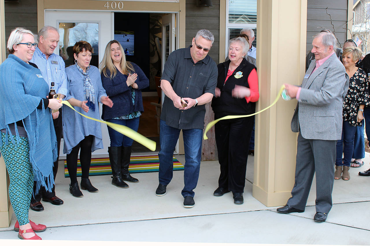 North Coast News photo: Patrick Brunstad cuts the ribbon for the new management team at Oyhut Bay with Chamber Director Piper leslie, far left, and Chamber Ambassador Ernie Nelson, right, holding the ribbon and Mayor Crystal Dingler on hond for the festivities.