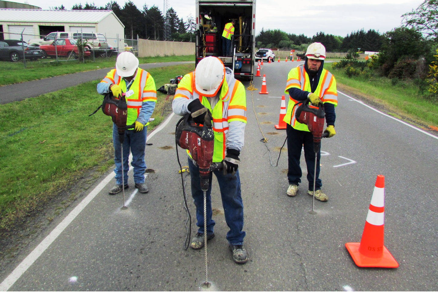 Photo by Scott D. Johnston: Workers from Uretek USA drilled holes in the pavement on Canal Drive in Ocean Shores Thursday as part of preparing for a test of a polyurethane injection process for roadbed stabilization and pavement lifting. The result for the big dip on Canal was that “ride quality is significantly better, but still not perfect,” Ocean Shores Public Works Director Nick Bird said.