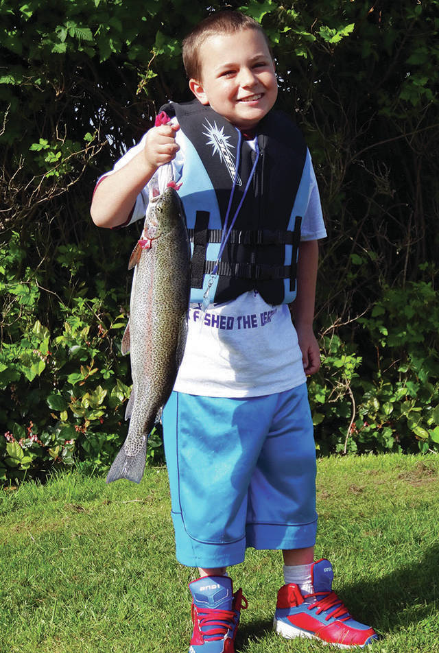 North Coast News file photo: This youngster shows off his catch in a past Ocean Shores Youth Fishing Derby on Duck Lake.