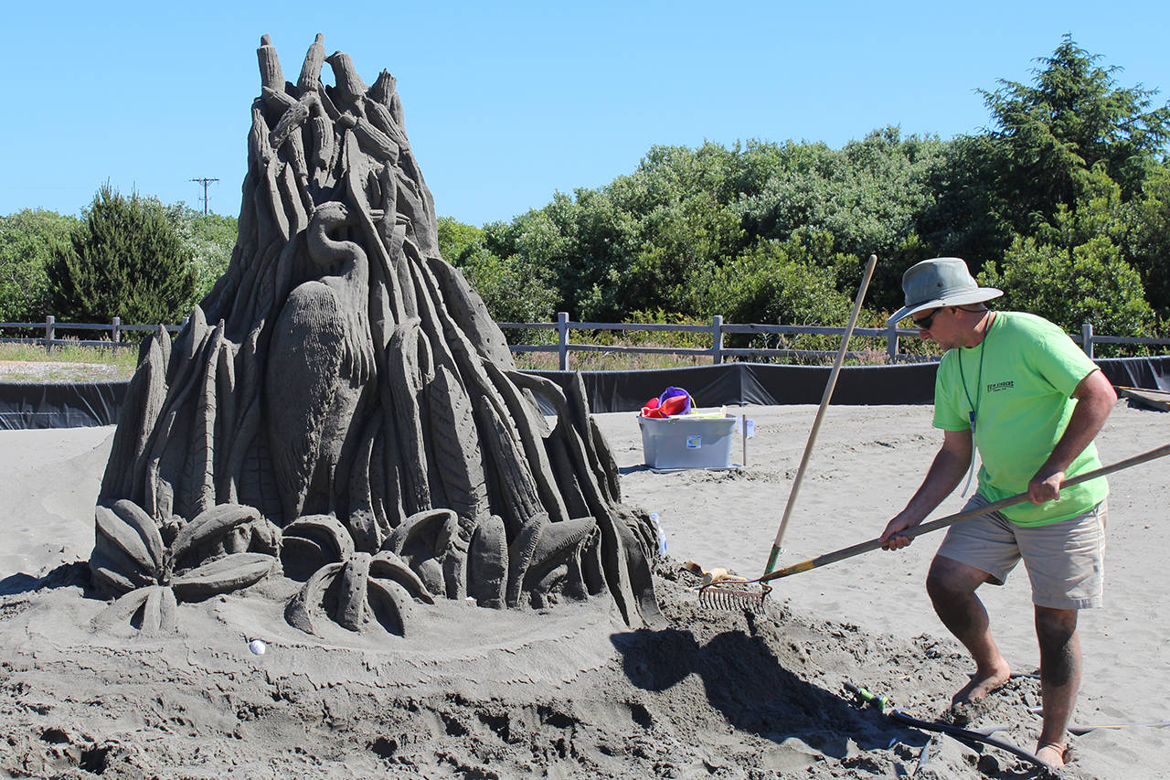 Angelo Bruscas/North Coast News photo: Jim Butler of the Form Finders team works on his signature Oyhut Bay sand sculpture during Ocean Shores Sand & Sawdust Festival in Ocean Shores.