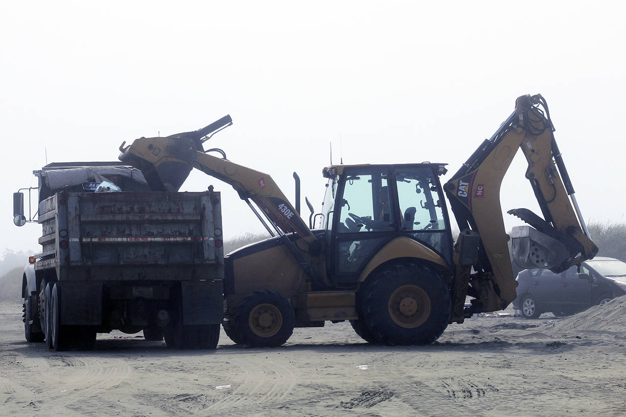 Ocean Shores city crews work to load up the garbage and trash collected on the beaches after the Fourth of July.