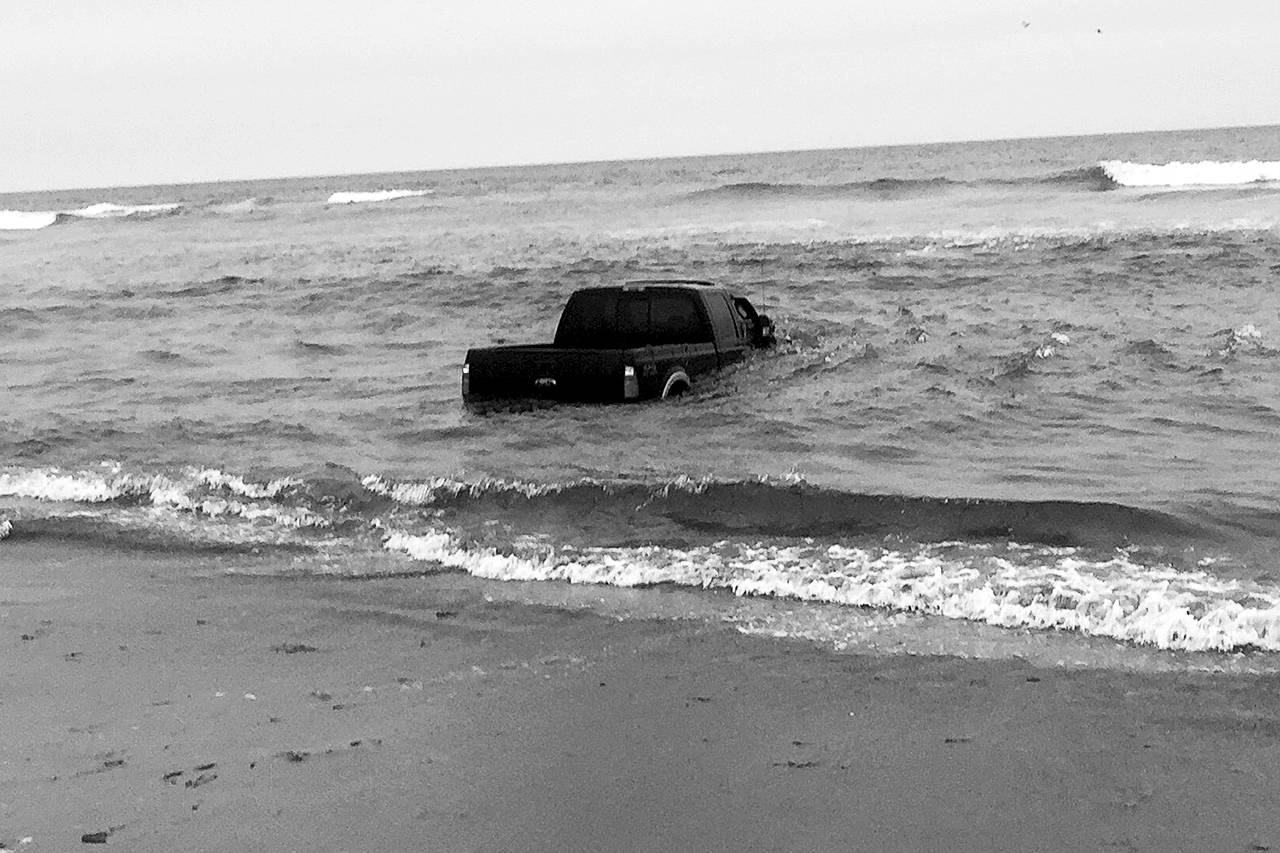 Ocean Shores Fire Department photo: This full-sized truck was swamped by the ocean surf last Sunday. The two people reported to be in the vehicle managed to escape without injury, but the truck was a total loss.