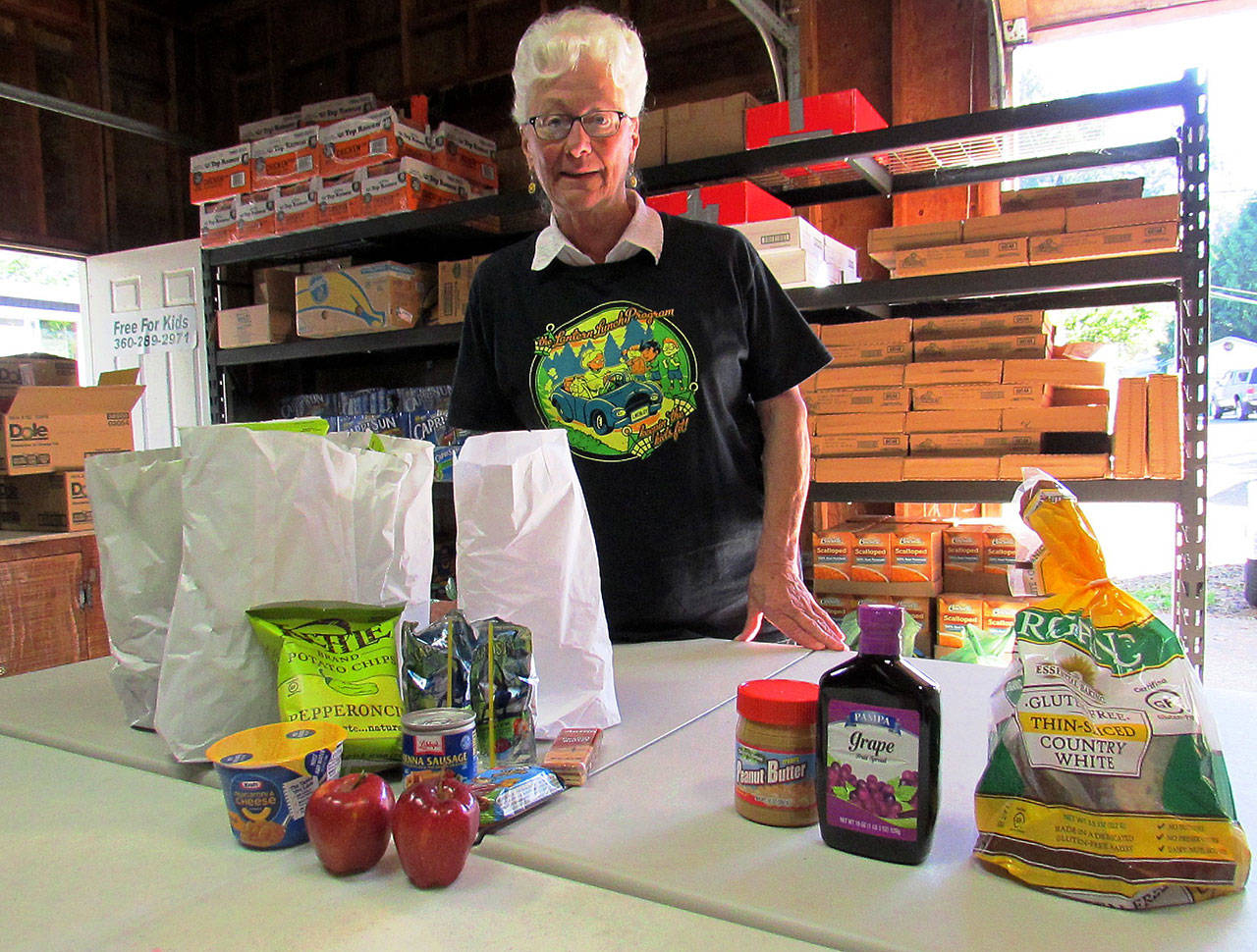 Scott D. Johnston photo: Phyllis Shaughnessy is pictured with a weekend food pack for four, with four individual weekend lunch bags and some extra family items, meant to feed four kids for two days
