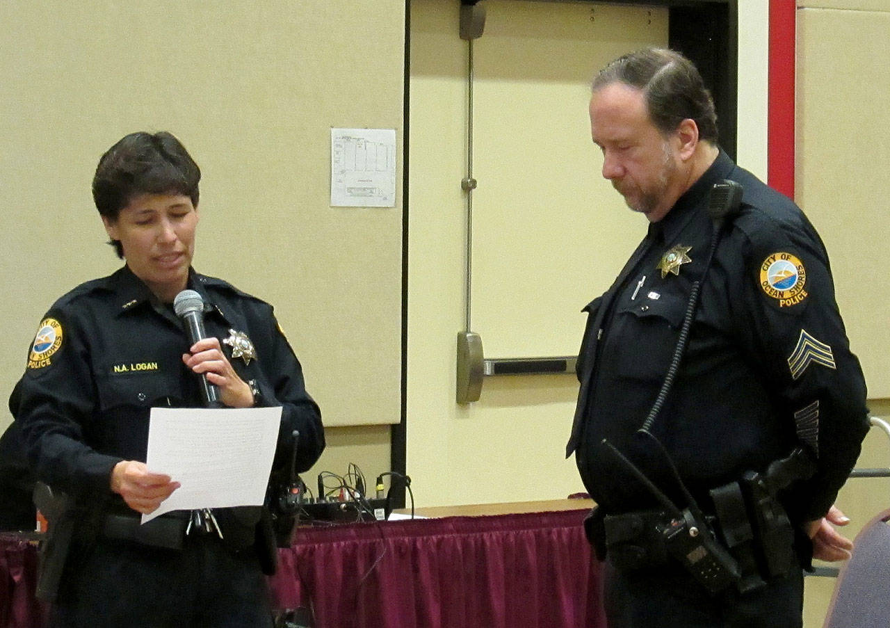Scott D. Johnston photo: Ocean Shores Police Chief Neccie Logan, left, reads a proclamation honoring Sgt. Dave McManus for more than 30 years of service for the department.