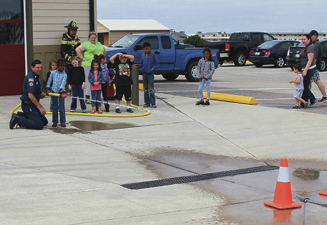 North Coast News: Fire Department Fire Inspector Curt Begley shows the kids how to use a fire house at a past Open House.