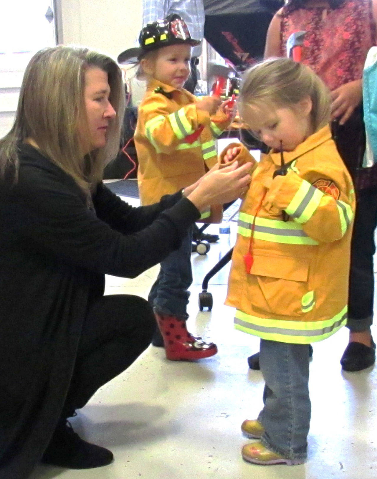 Courtney Beebe helps some young firefighting recruits suit up.