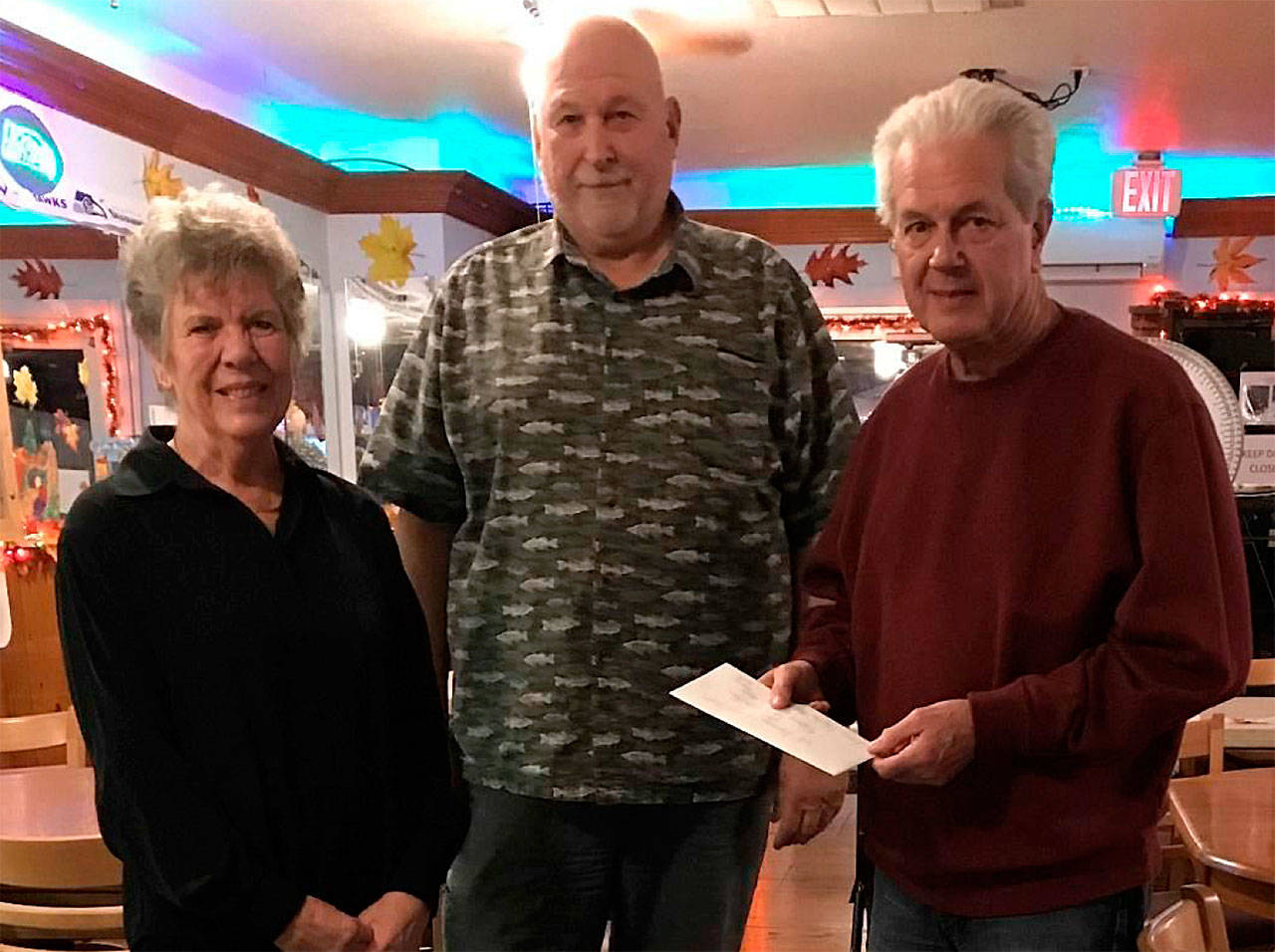 Pat Scott, Jim Westergaard (Eagles Worthy President) and Donvoan Scott, receiving the check for the Kids Christmas Party on Dec. 16.