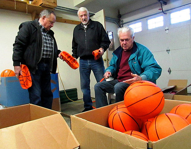 Volunteers Don Ross and Bob Tinker help Donovan Scott inflate boxes of basketballs in preparation for the annual the Kiwanis North Beach Kids Christmas Party, taking place at the Ocean Shores Convention Center this Saturday, December 16 from 1-4 p.m.