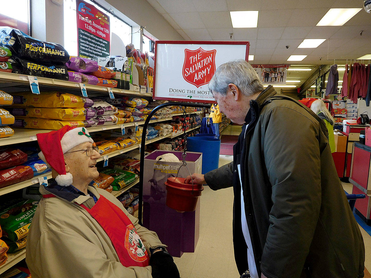 Betsey Seidel photo: Arnold Samuels collects a donation from Alec Takagi at the Ocean Shores IGA, where Samuels is in his 15th year as a Kettle Bell Ringer for the Salvation Army.
