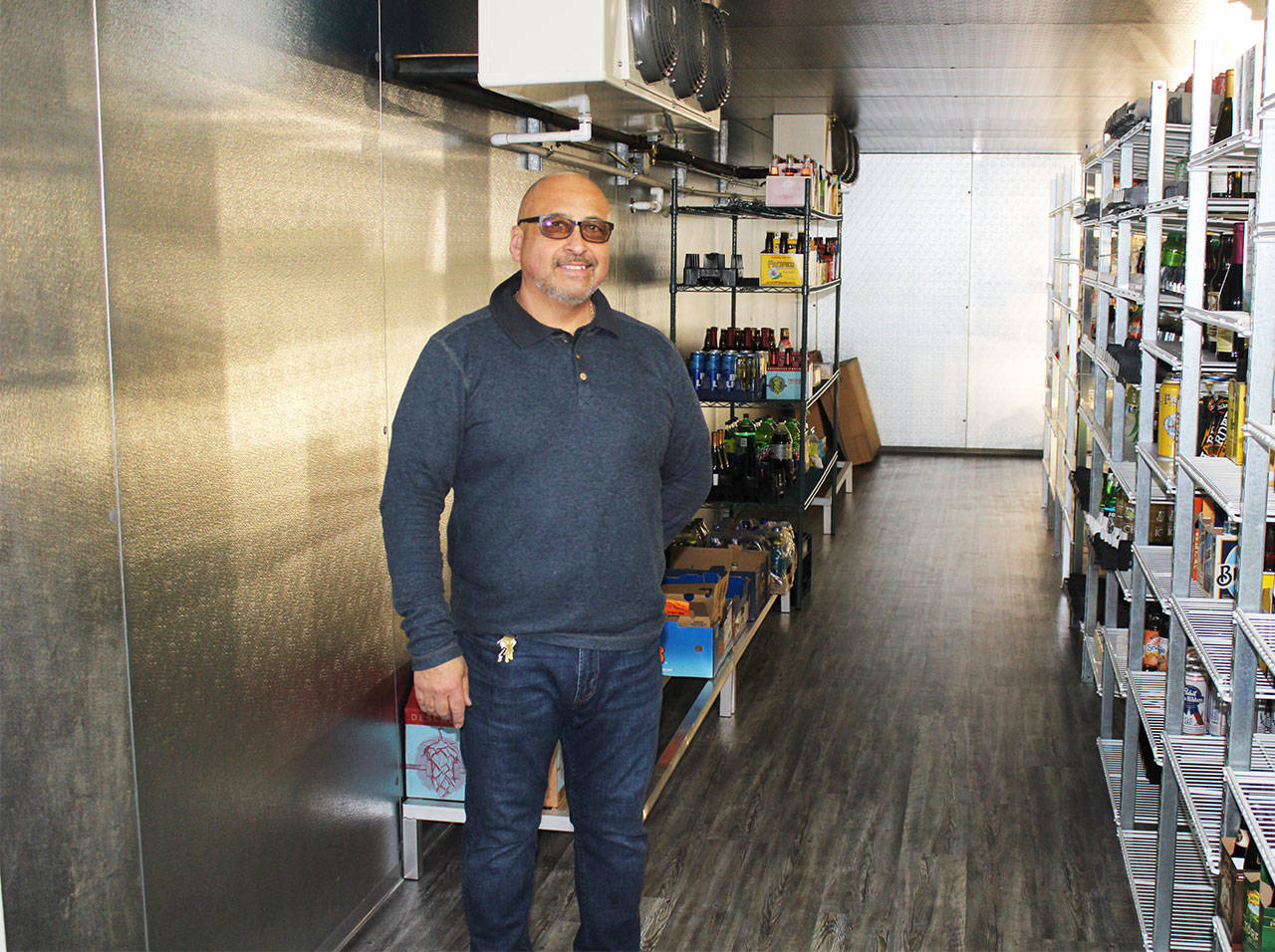 Angelo Bruscas/North Coast News                                Carlos Villarreal shows the spacious walk-in refrigerated storeroom, where the wide selection of beverages and dairy items can be easily restocked.
