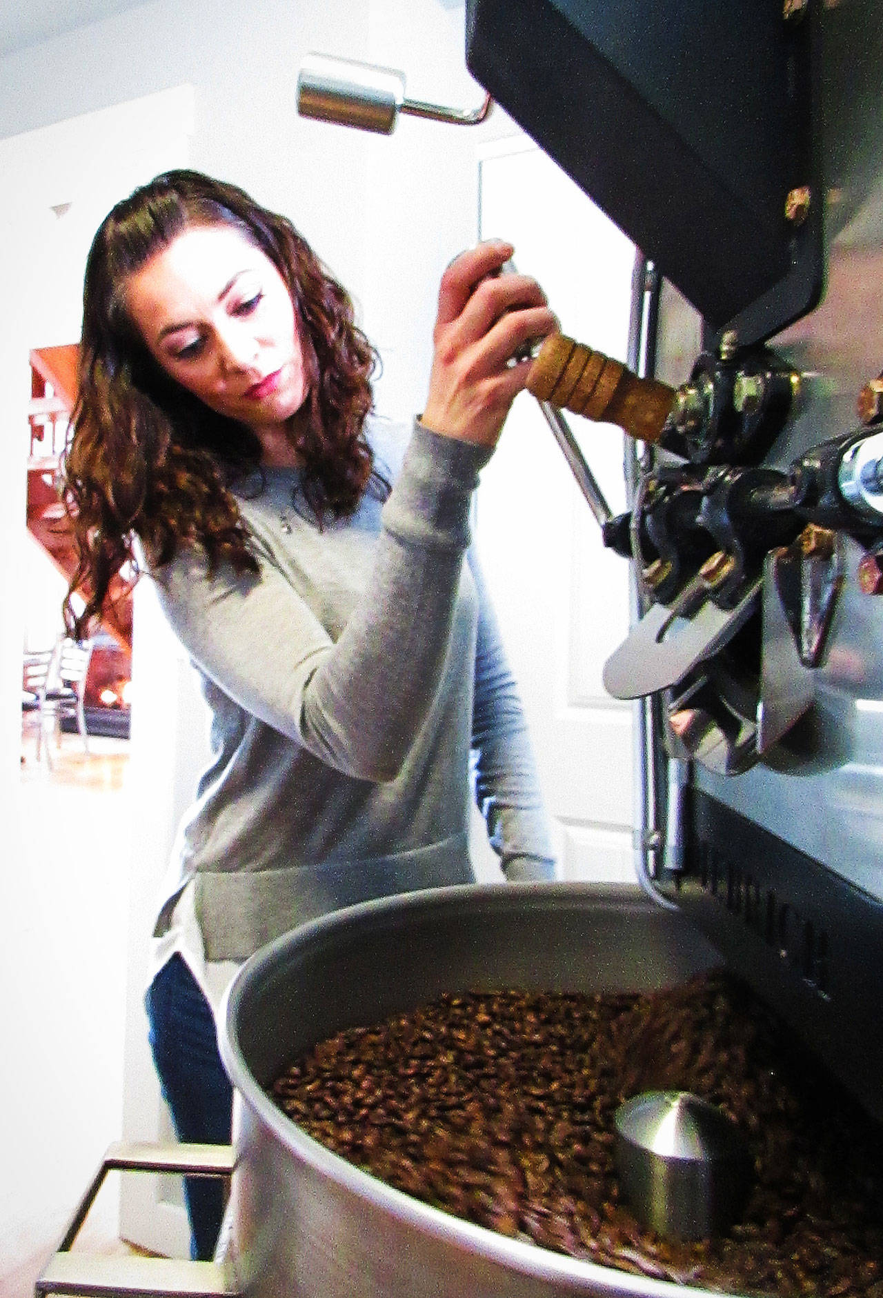 Mirihia roasts fresh coffee with the new “craft/artisan” machine recently added at Ocean Beach Roasters & Bistro. Photo by Scott D. Johnston.