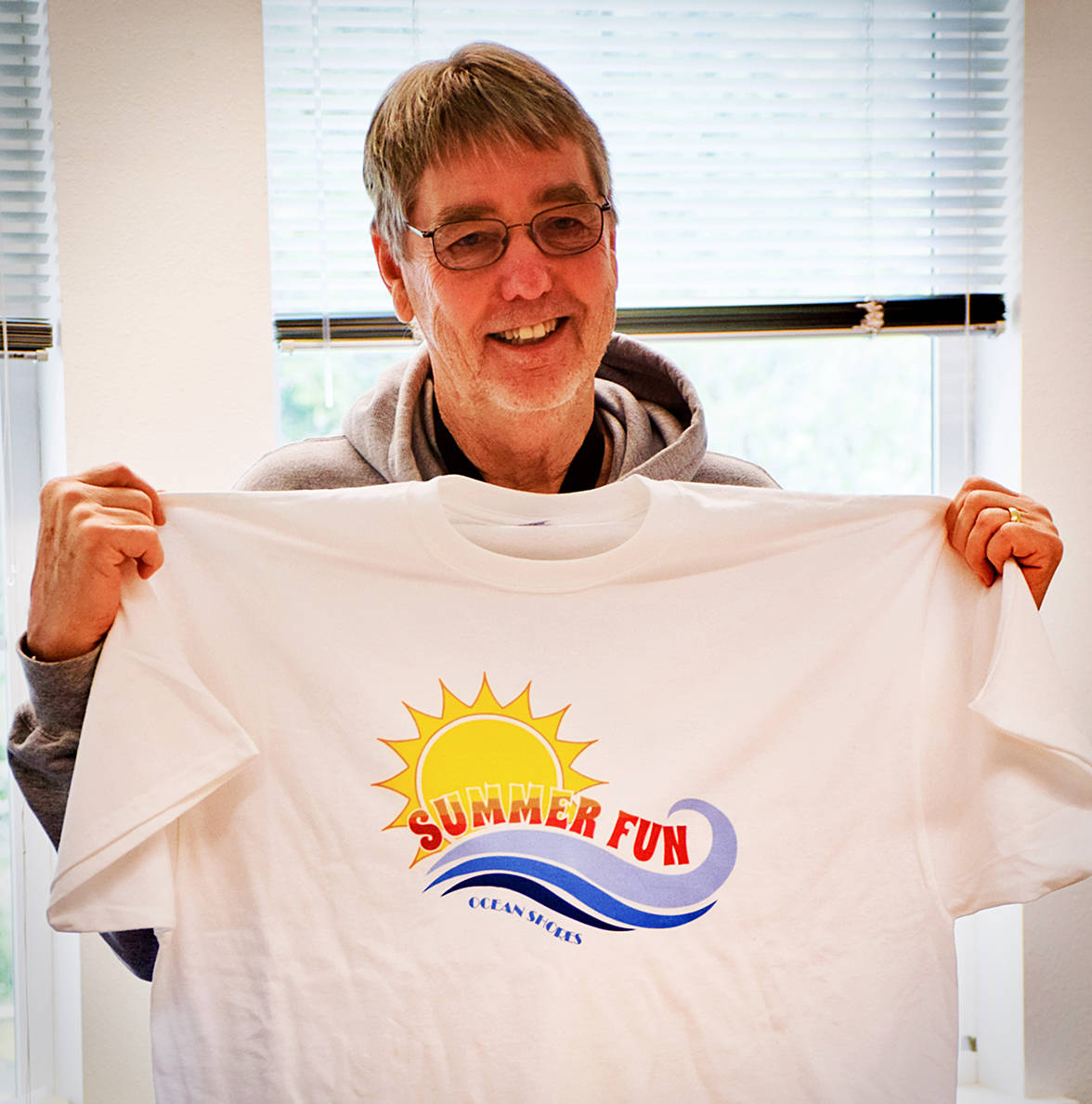 Bob Peterson displays the free T-shirt that North Beach students ages 8-14 will receive when they participate in the Free Summer Fun program at Ocean Shores Elementary School, July 9-27.