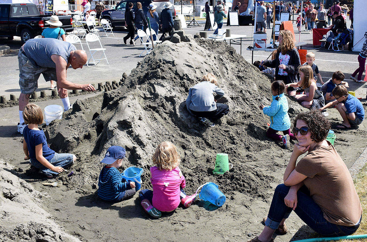Sand sculptor Doug Orr has a lot of youthful help creating a giant sand castle in the Convention Center parking lot.