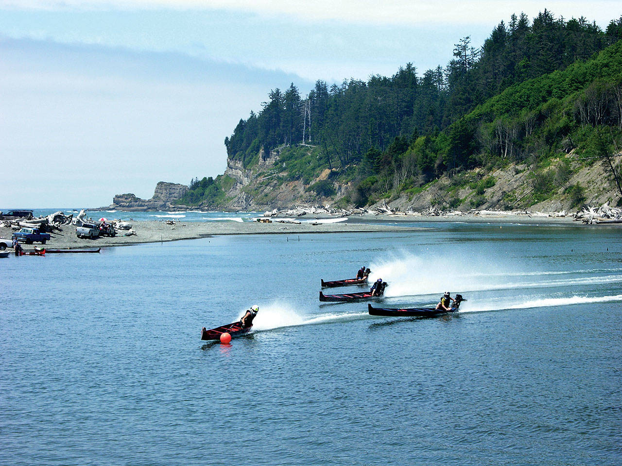 Larry Workman photo: Canoes race at the mouth of the Quinault River during Chief Taholah Day competition.