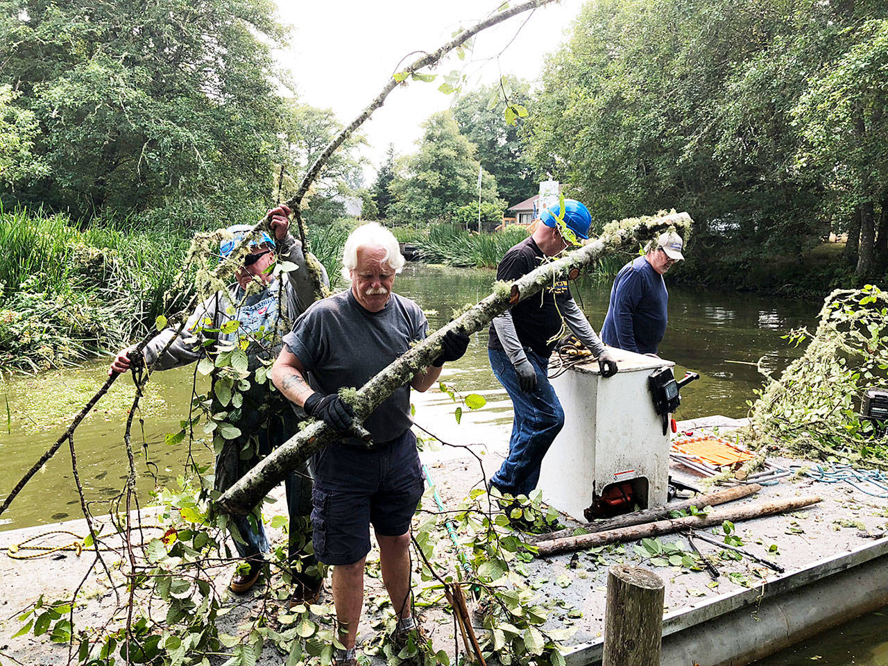 Molly Williams photo: Members of the Fresh Waterways Corp. work along a canal to help clear the debris.