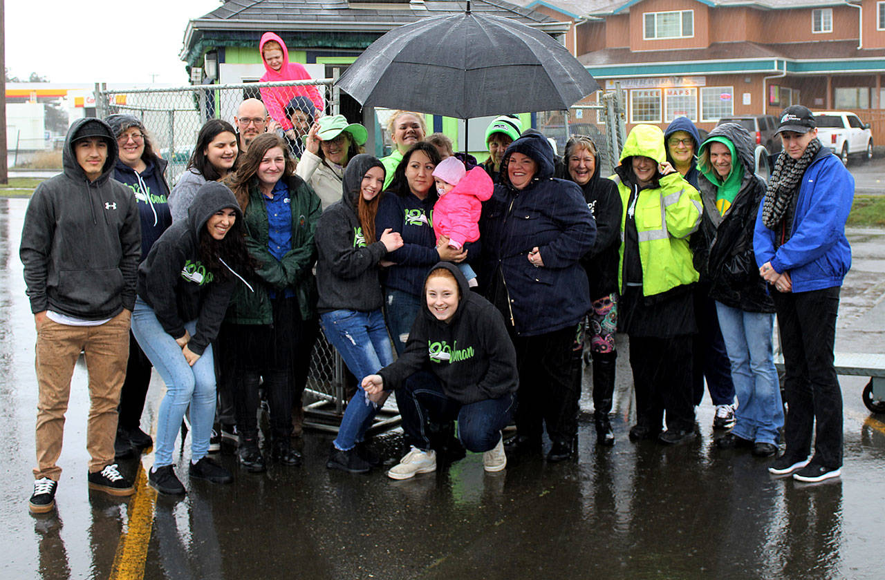 Angelo Bruscas photo: Workers, customers and supporters of the 12th Woman Espresso Stand gather in the pouring rain last Wednesday after it was learned the popular drive-through coffee business was being closed in the redevelopment project now underway on the commercial property.