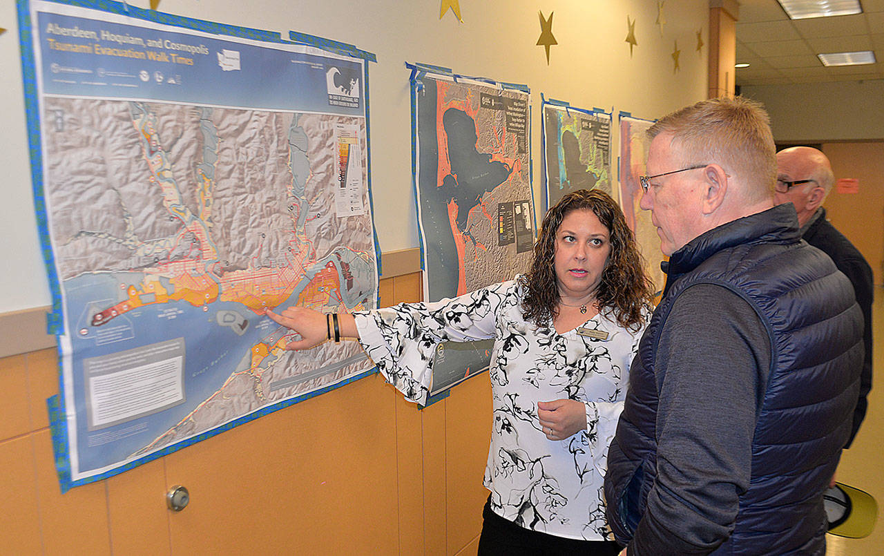 DAN HAMMOCK | GRAYS HARBOR NEWS GROUP                                Keily Yemm, Tsunami Program Coordinator with the Washington State Military Department, shows the recently updated walking time tsunami evacuation route map for Aberdeen to Grays Harbor County Commissioner Randy Ross.