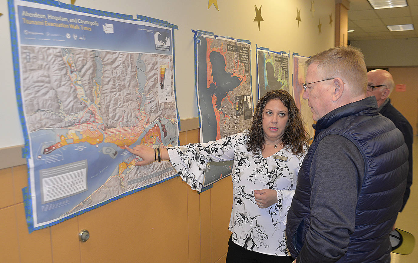 DAN HAMMOCK | GRAYS HARBOR NEWS GROUP                                Keily Yemm, Tsunami Program Coordinator with the Washington State Military Department, shows the recently updated walking time tsunami evacuation route map for Aberdeen to Grays Harbor County Commissioner Randy Ross.