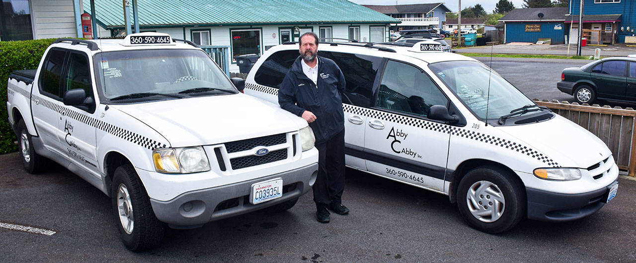 Scott D. Johnson | Grays Harbor News Group                                Abby Cabby General Manager Jim Monroe with part of the Abby Cabby fleet in front of the taxi service’s new North Coast office at 802 Ocean Shores Blvd. NW.