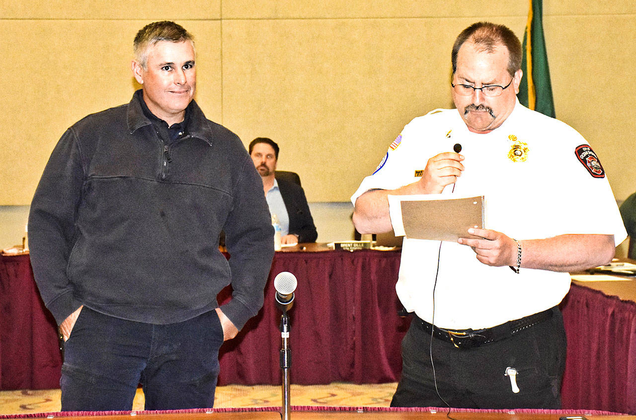 Ocean Shores Fire Deartment Chief Mike Thuirer, right, congratulates Capt. Matt Krick on his upcoming retirement after 21½ years. (Photo by Scott D. Johnston)