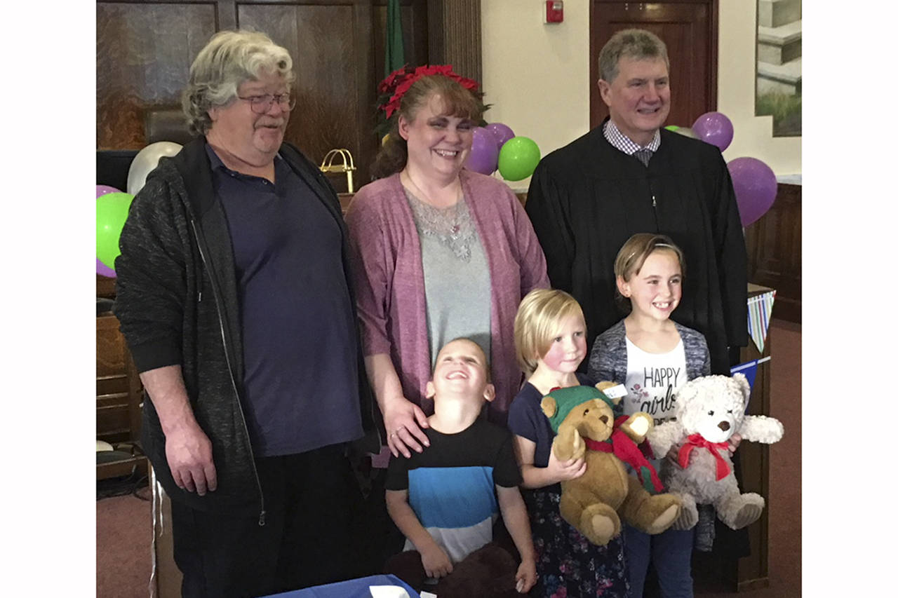 (Todd Bennington | The Vidette)                                Dennis and Stacy Parish were one of two families adopting as part of a National Adoption Day celebration at Grays Harbor County Superior Court on Nov. 17, 2017. The couple at the time had three adopted children. At right is Judge Stephen Brown who presided over the ceremony.