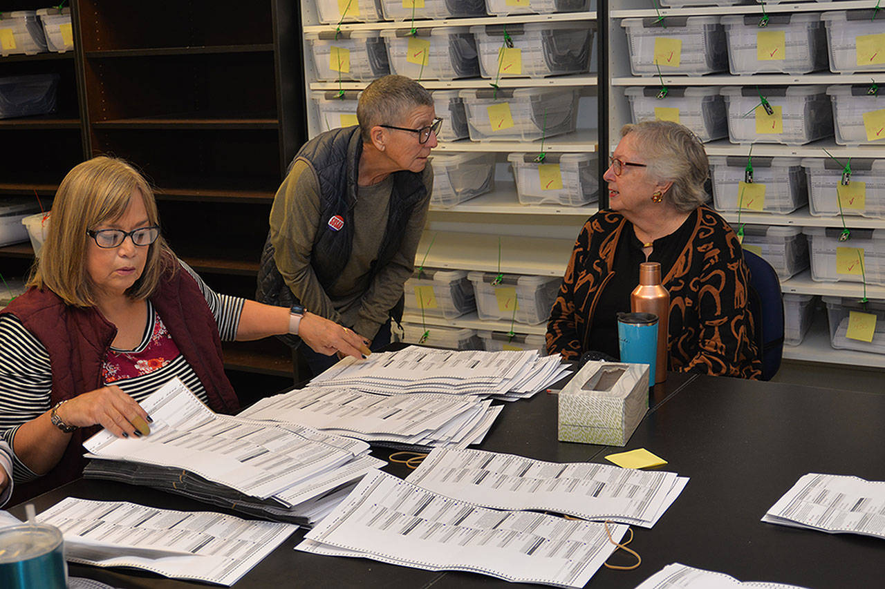 Challenger Susan Conniry, center, confers with incumbent Crystal Dingler, right,) while election worker Kathye Lano sorts ballots on Dec. 3. (Photo by Thorin Sprandel | Grays Harbor News Group)