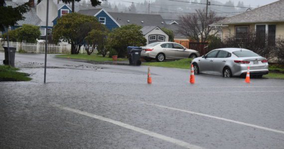Orange traffic cones on Thursday, Jan. 6, 2022, block drivers from heading down the then-flooded Bay Avenue near A.J. West Elementary School, in Aberdeen. Grays Harbor County commissioners approved $30,000 for flood vouchers to help county residents clean up their flood debris. (Matthew N. Wells | The Daily World)