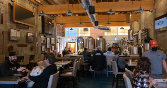 Patrons enjoy a Friday afternoon at Hoquiam Brewing Co. on Feb. 18, 2022. According to co-owner Rob Paylor, the recently expanded kitchen and dining menu has been well-received by the public and features “Northwest Brewery pub-style” cuisine. Erika Gebhardt I The Daily World