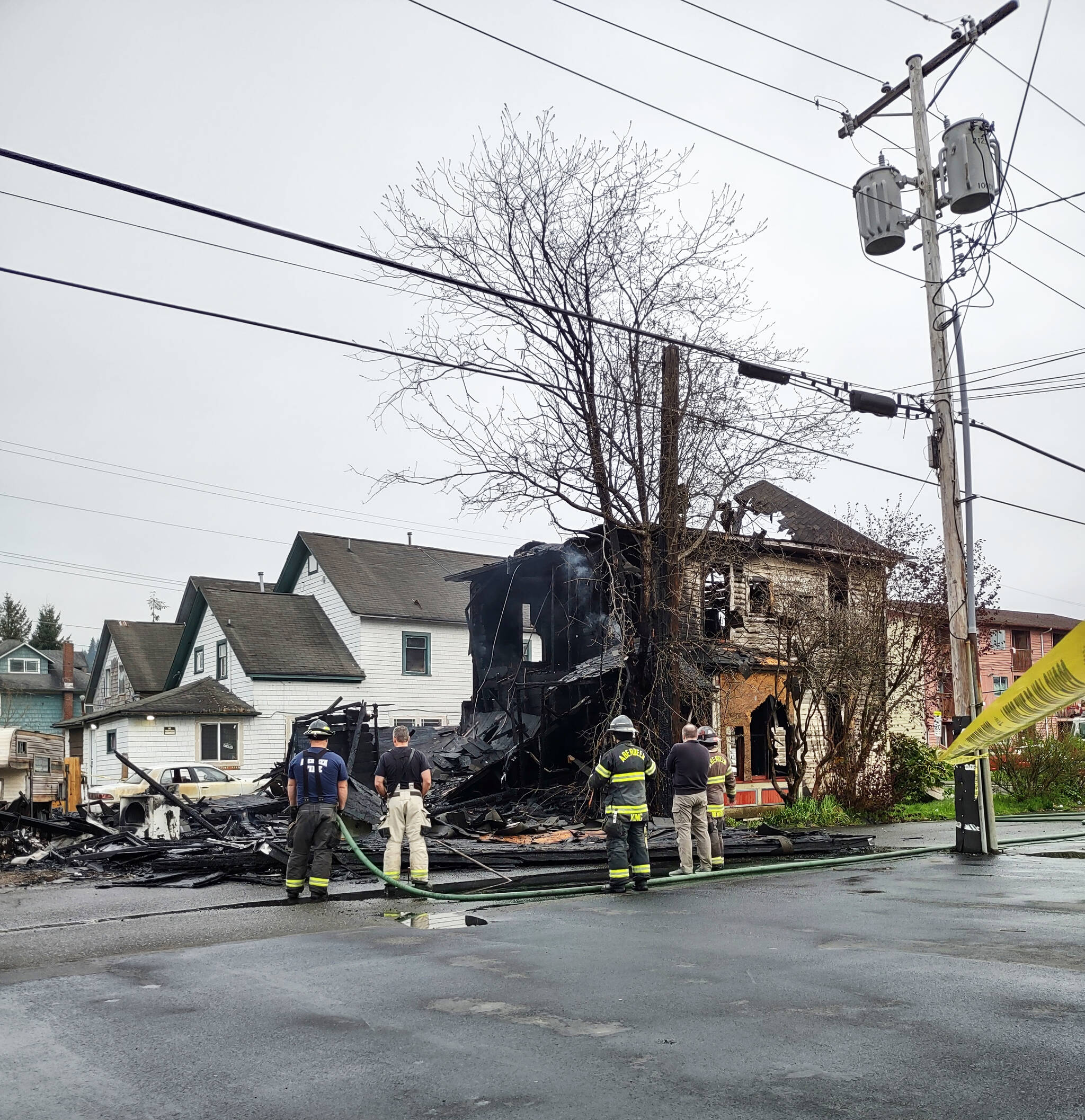 Aberdeen Firefighters look on at the damage to the two-story “vacant” residence that fire destroyed Saturday morning, April 23, at 215 N. H St., in Aberdeen. (Christopher Woodland)