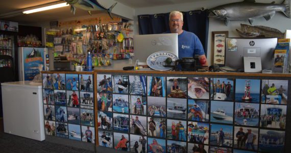 Matthew N. Wells | The Daily World
                                Eric McMurry, owner of Ocean Sportfishing Charters, stands behind a counter that features all local catches from past years in and around Westport. The Westport community is learning to integrate traditional industry into its tourism offerings to create unique and authentic experiences in Grays Harbor.