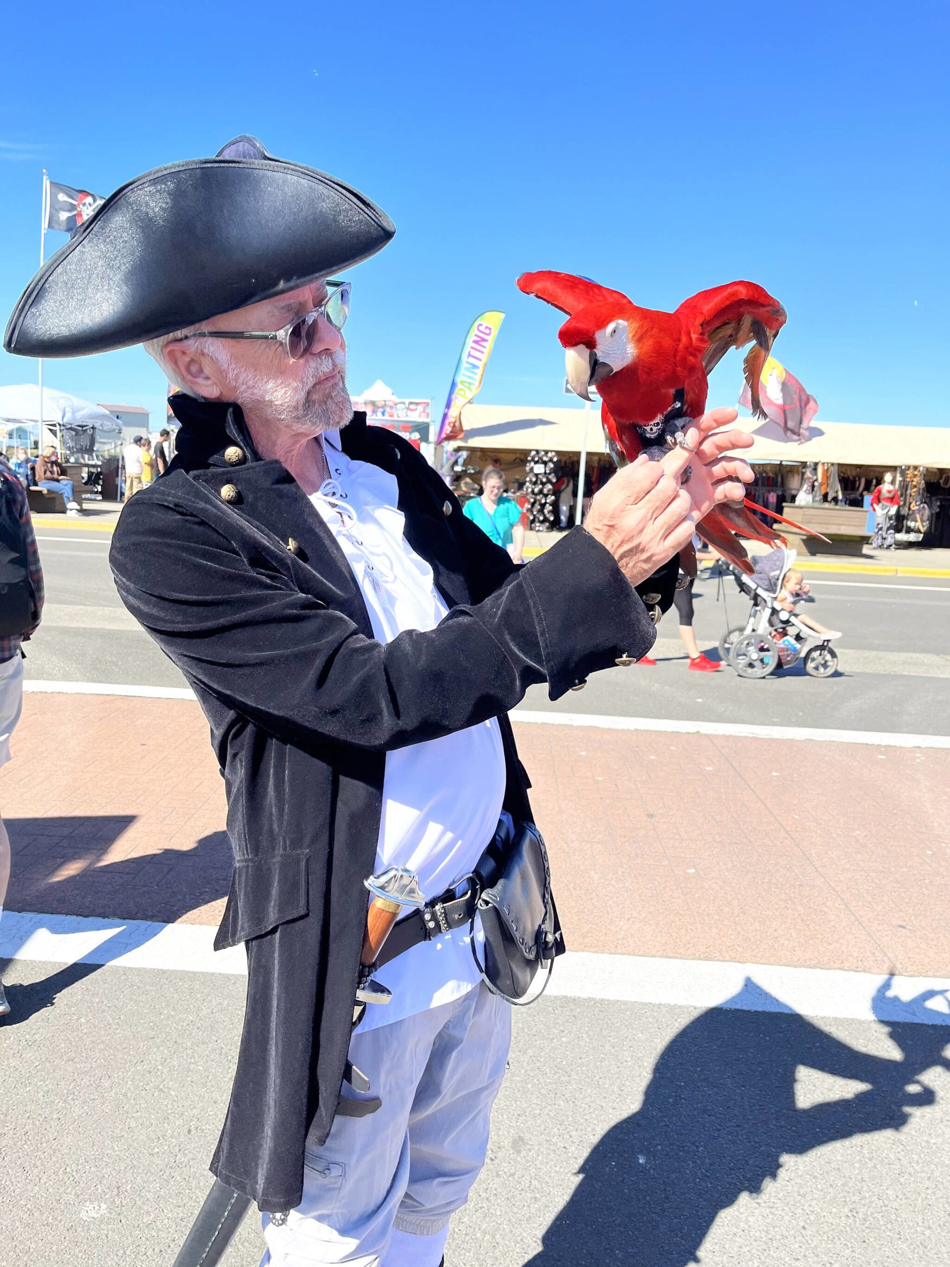 Matthew N. Wells | The Daily World Ron Schmidt, and his 45-year old macaw named Jazz, were a sight to see on Friday, June 24, 2022, for fair attendees at the Rusty Scupper’s Pirate Daze festival in Westport. Schmidt was cheerfully showing off what she could do, and was insistent on those who wanted photos of the duo to take “selfies” with him. Schmidt was just happy to play like a “kid” again.